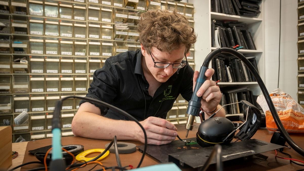 Techniker arbeitet mit der Heißluftstation an einer Platine in der Werkstatt in Dresden-Neustadt